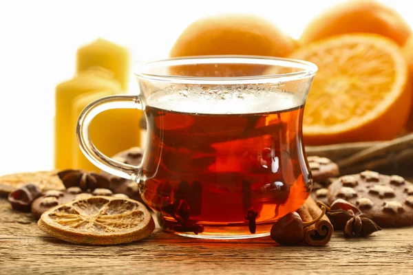 Glass of hot steaming tea among christmas decorations — Stock Photo, Image