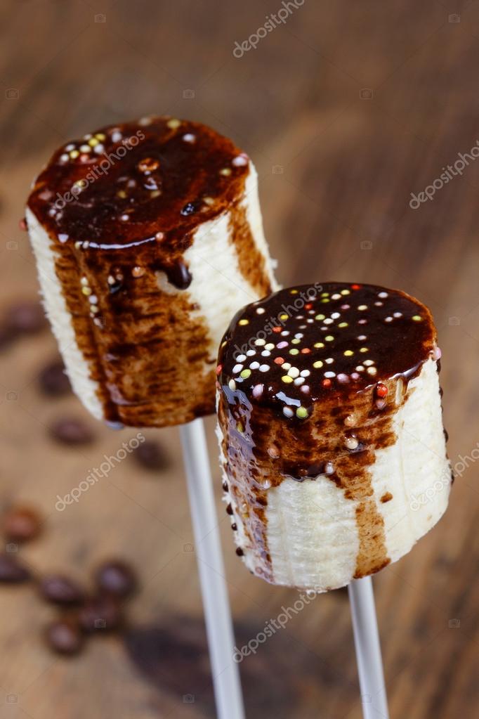 Banana cake pops with chocolate and colorful sprinkles Stock Photo by