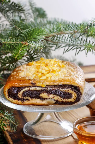 La torta di seme di papavero su bancarella di torta di vetro sotto ramo di abete. Natale! — Foto Stock