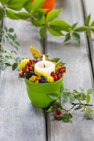 Ljusstake dekorerad med höstens blommor och andra växter. — Stockfoto