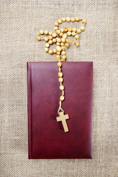 Santa Biblia y rosario sobre fondo de yute. Copiar espacio —  Fotos de Stock