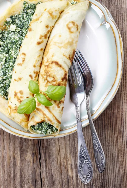 Mediterranean cuisine: crepes stuffed with cheese and spinach — Stock Photo, Image