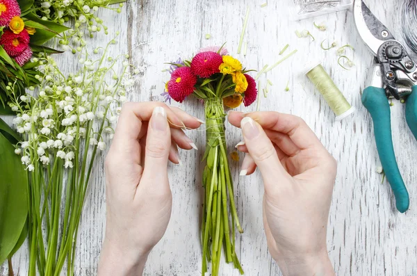 Florist bei der Arbeit. Frau macht Strauß aus Wildblumen — Stockfoto