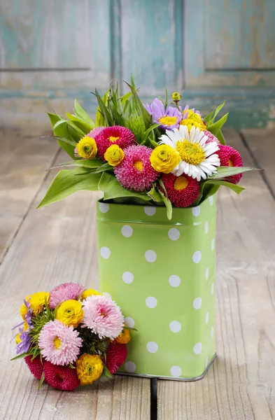 Boeket van kleurrijke wilde bloemen in groene gestippelde kan — Stockfoto