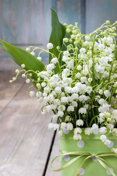 Blumenstrauß der Maiglöckchen in grün gepunkteter Dose — Stockfoto