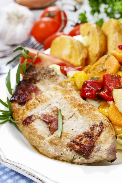 Joint of pork with baked potatoes and fresh vegetables — Stock Photo, Image