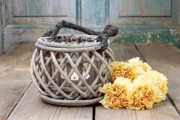 Vintage lantern and bouquet of yellow carnations on rustic woode — Stock Photo, Image