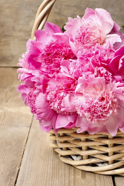 Cesto di graziose peonie rosa, sfondo rustico in legno — Foto Stock