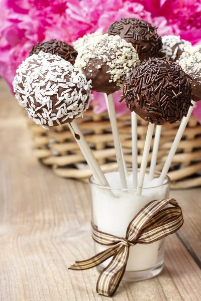 Bolo de chocolate aparece na mesa de madeira. Cesta de peônias rosa — Fotografia de Stock