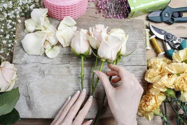 Fleuriste au travail. Femme faisant bouquet de mariage de roses roses et — Photo