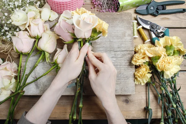 Florista no trabalho. Mulher fazendo buquê de casamento de rosas rosa e — Fotografia de Stock