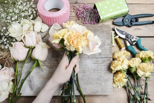 仕事で花屋。ピンクのバラの結婚式のブーケを作る女性と — ストック写真