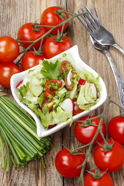 Bowl of fresh salad on rustic wooden table — Stock Photo, Image