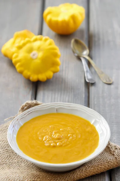 Kürbiscremesuppe in Keramikteller auf Holztisch — Stockfoto