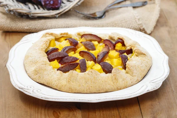 Pumpkin, plum and apricot galette on wooden table — Stock Photo, Image