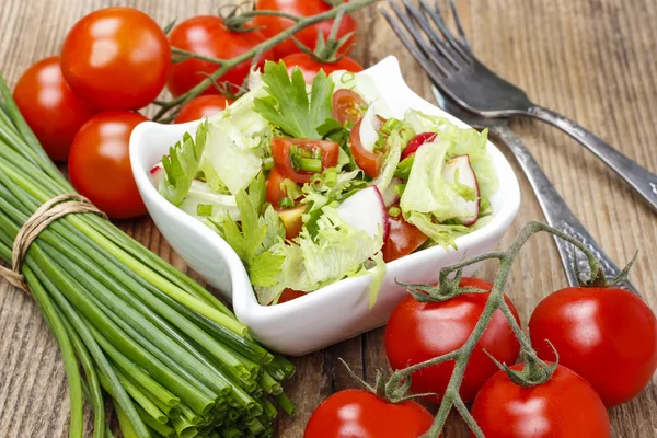 Skål med fräsch sallad på rustika träbord — Stockfoto