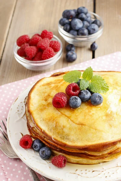 Stack of pancakes with syrup, raspberries and blueberries — Stock Photo, Image