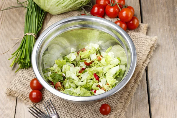 Skål med fräsch sallad på träbord — Stockfoto