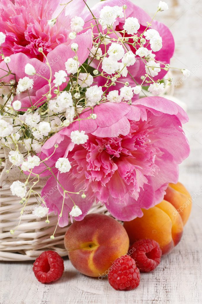 Basket of pretty pink peonies, white rustic background, 