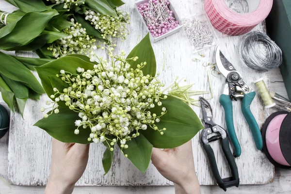 Florist at work. Woman making bouquet of lily of the valley flow — Stock Photo, Image