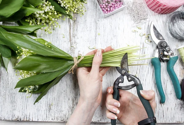 Florist på jobbet. Kvinna att göra bukett av Liljekonvalj flöde — Stockfoto