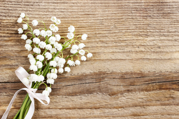 Lily of the valley flowers on wooden background.