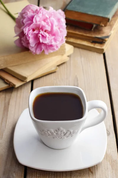 Tazza di caffè sul tavolo di legno. Libri d'epoca sullo sfondo — Foto Stock