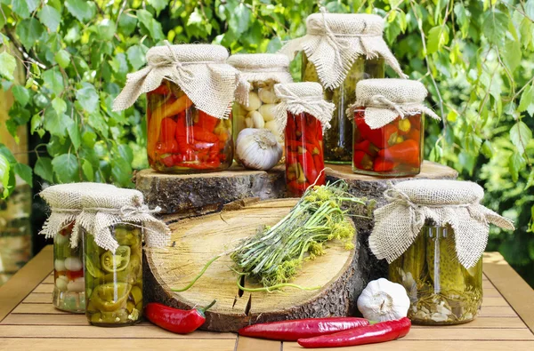 Potten van conserven op houten tafel in de tuin — Stockfoto