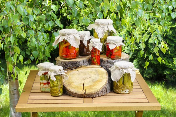 Jars of preserves on wooden table in the garden — Stock Image Jars of preserves on wooden table in the garden Stock Picture