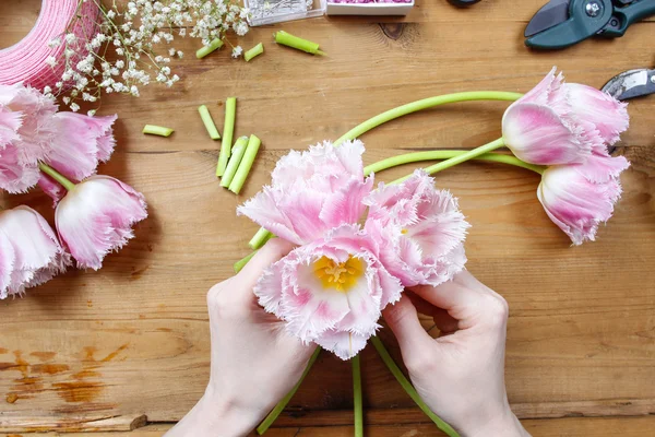 Florista en el trabajo. Mujer haciendo hermoso ramo de tulipanes rosados — Foto de Stock