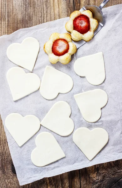 Faire des pâtisseries feuilletées en forme de coeur rempli de strawberri — Photo