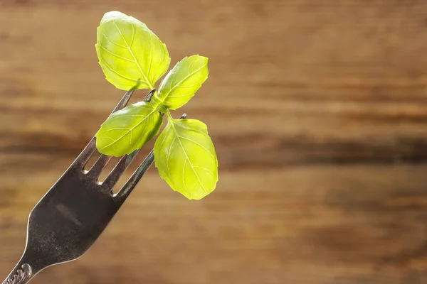 Basilicum bladeren geïsoleerd op houten achtergrond — Stockfoto