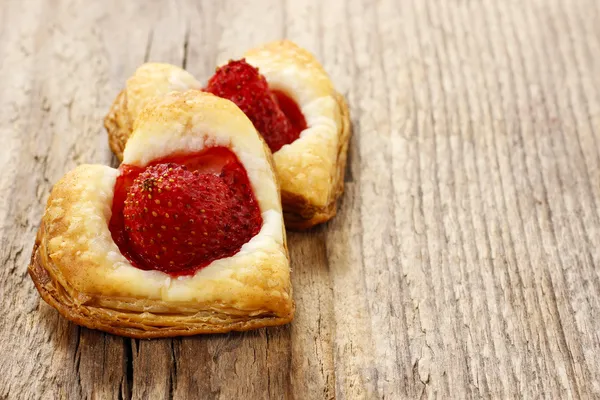 Puff pastry cookies in heart shape filled with strawberries. Cop — Stock Photo, Image
