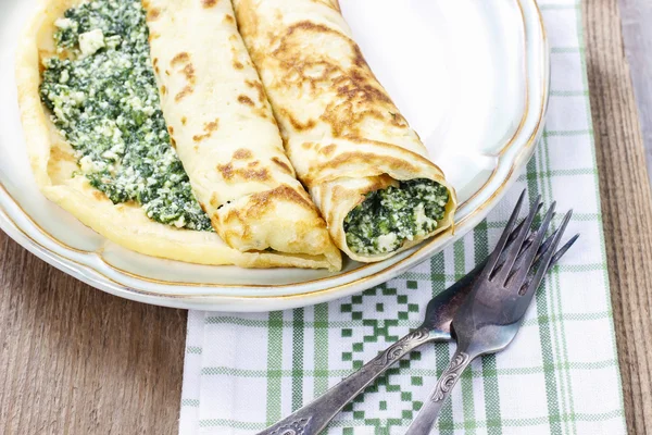 Mediterranean cuisine: crepes stuffed with cheese and spinach — Stock Photo, Image