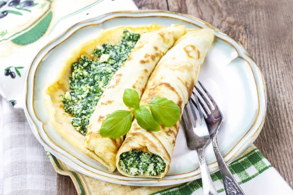 Mediterranean cuisine: crepes stuffed with cheese and spinach — Stock Photo, Image