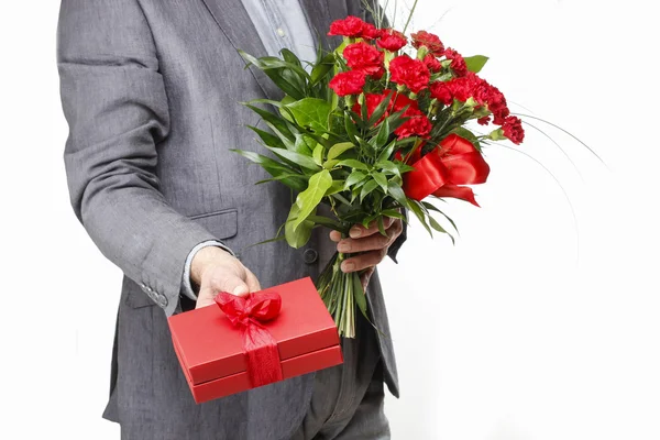 Hombre sosteniendo ramo de claveles rojos y caja de regalo roja con grandes —  Fotos de Stock