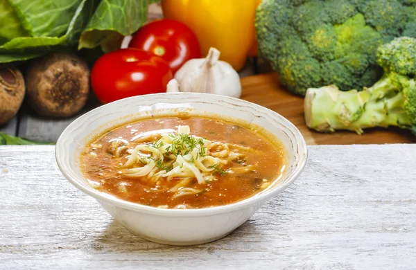 Bol de soupe aux tomates. Légumes frais en arrière-plan — Photo