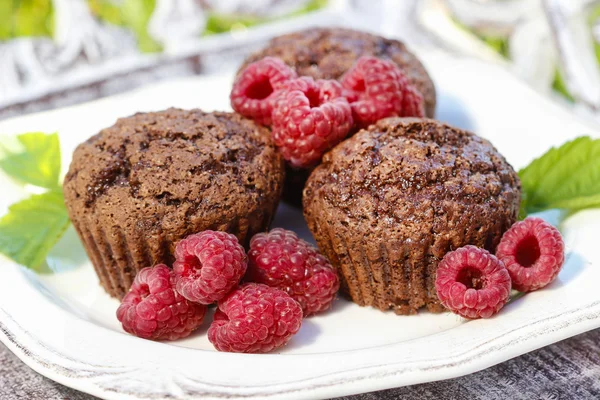 Muffins con frambuesas frescas en bandeja de madera en el jardín —  Fotos de Stock