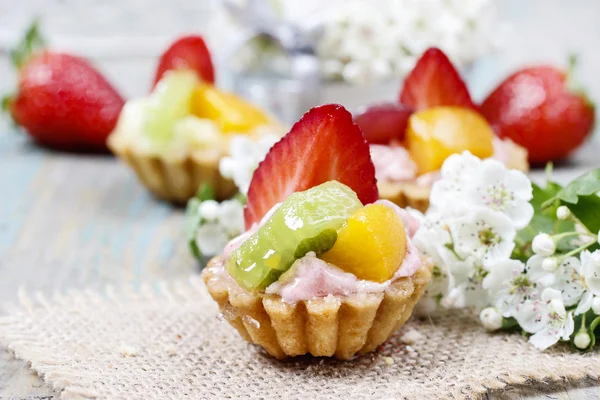 Schöne Cupcakes mit frischen Früchten dekoriert: Erdbeere, Erbse — Stockfoto