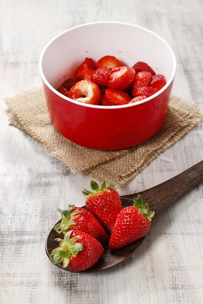 Cuenco rojo de fresas de pie sobre una mesa de madera. Copiar espacio — Foto de Stock