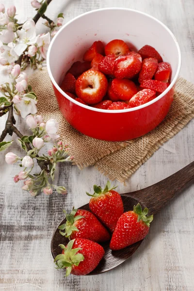 Red bowl of strawberries standing on wooden table. Copy space — Stock Photo, Image