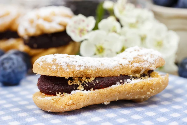 Eclairs med blåbär marmelad. Blommande apple twig i bac — Stockfoto