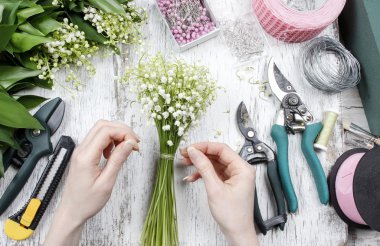 Çiçekçi iş başında. Lily vadi akışı buket yapma kadın