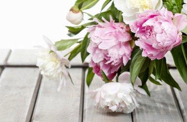 Stunning peonies in white wicker basket on rustic wooden table i