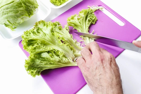 Мужчина режет салат — стоковое фото