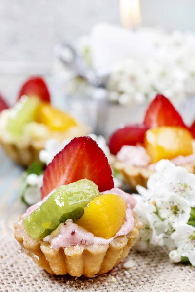 Hermosos cupcakes decorados con frutas frescas: fresa, melocotón —  Fotos de Stock