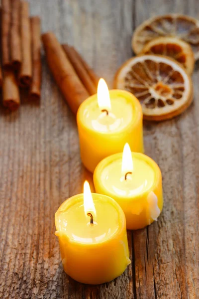 Beautiful candles and juicy oranges on jute table cloth — Stock Photo, Image