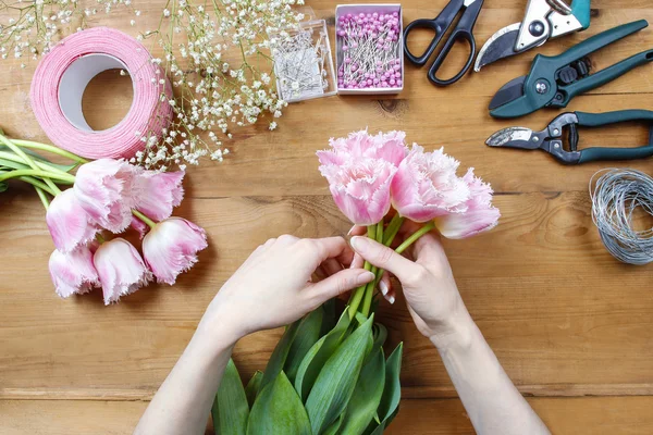 Florist bei der Arbeit. Frau macht schönen Strauß aus rosa Tulpen — Stockfoto