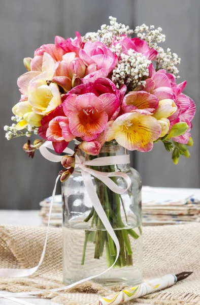 Bouquet of colorful freesia flowers in transparent glass vase. W — Stock Photo, Image