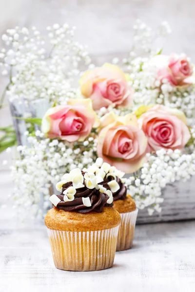 Chocolade cupcakes voor bruiloft receptie. Boeket van roze rozen — Stockfoto